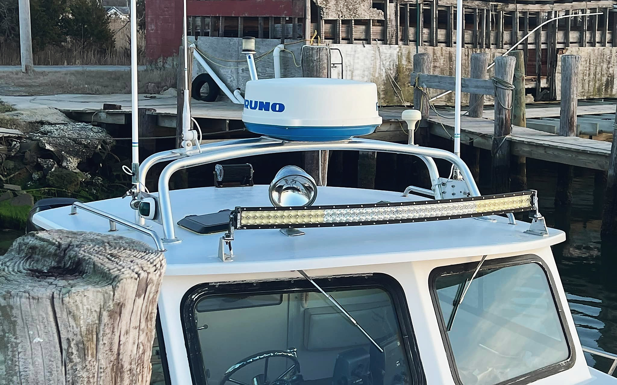 An aluminum rail across a cabin top, radar and light bar mounted on it