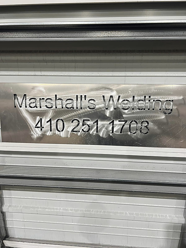 The shop’s name and number, cut into a panel