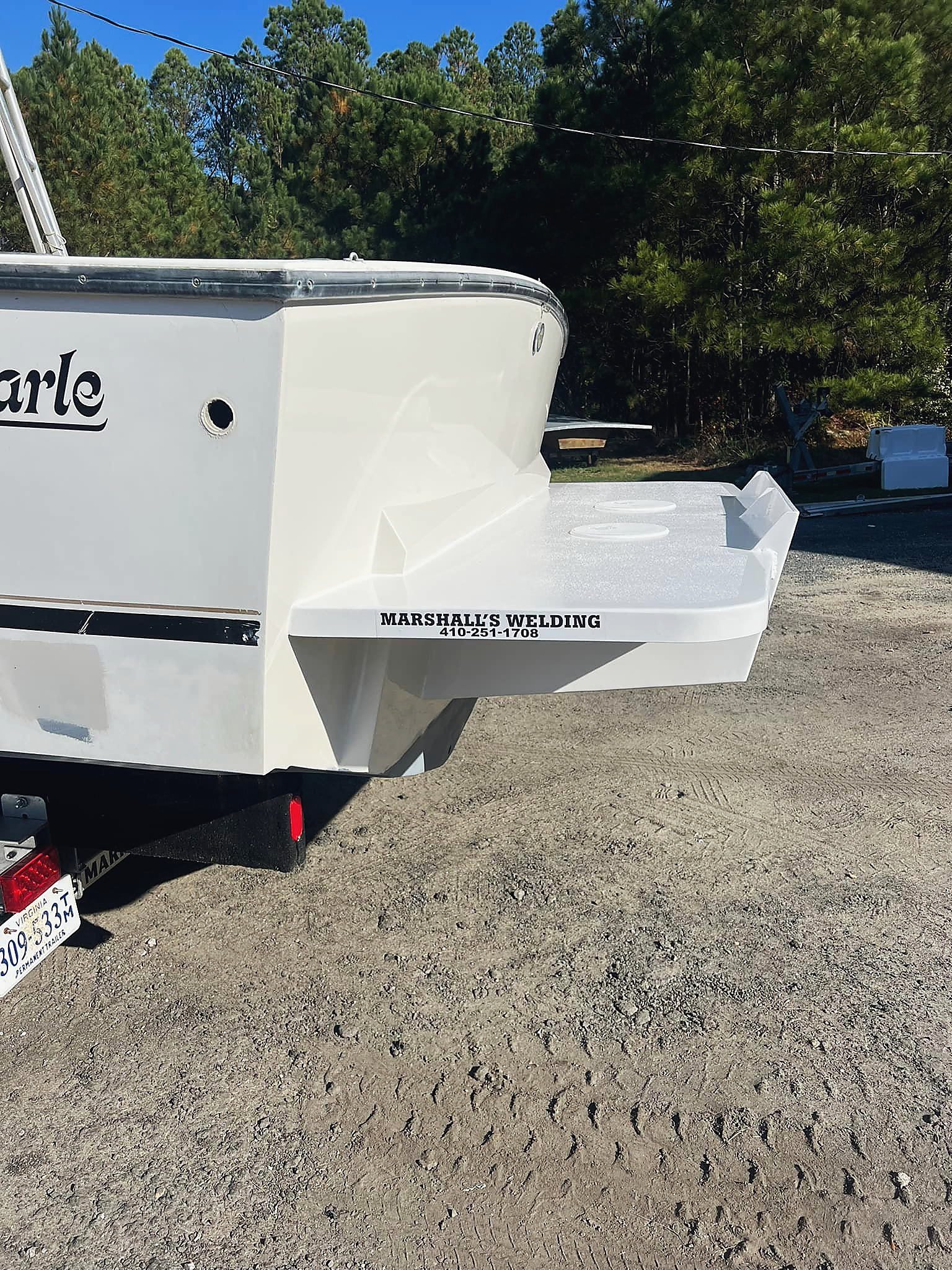 A transom bracket, painted, with the shop name lettered on it